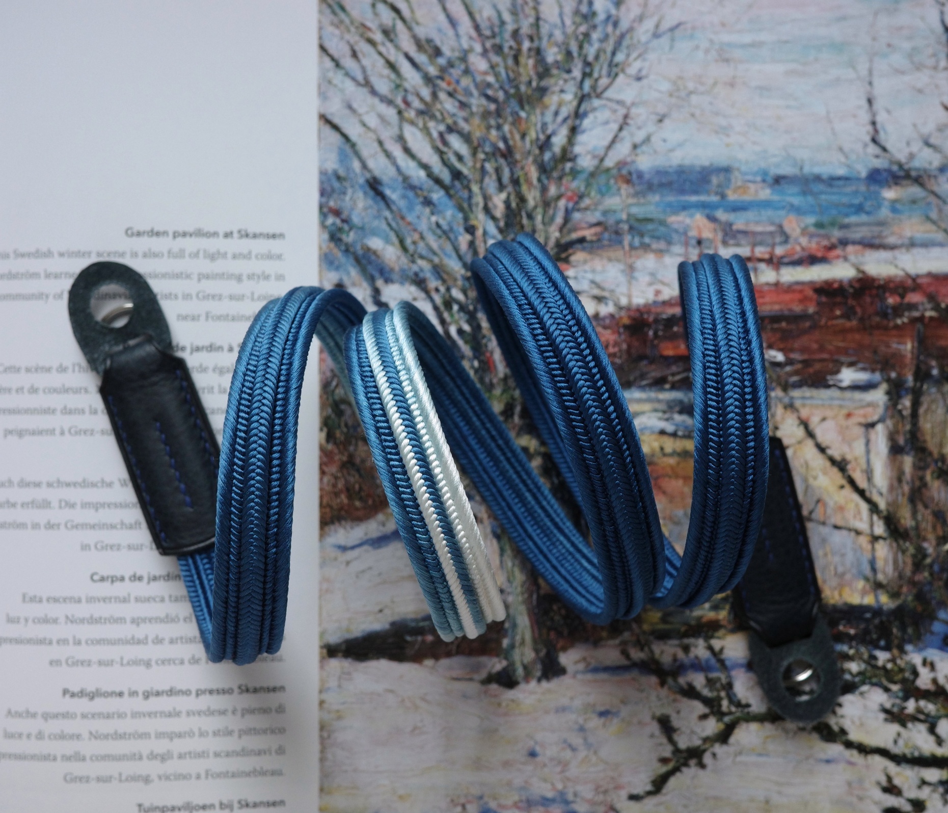 Close up of HOZUMA Blue Mt. Fuji Kumihimo silk camera strap showing braided texture, attached to a black Leica M11 camera.